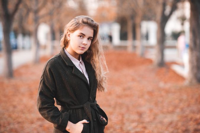 Portrait of teenage girl in dark coat standing outdoor