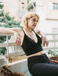 Charming calm woman resting on balcony in summer