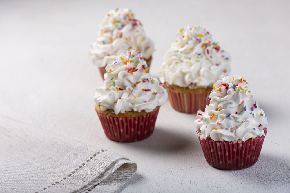 Tasty party cupcakes on the table. Cupcakes with whipped cream.