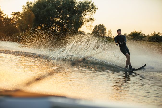 Man water skiing on a summer day at sunset