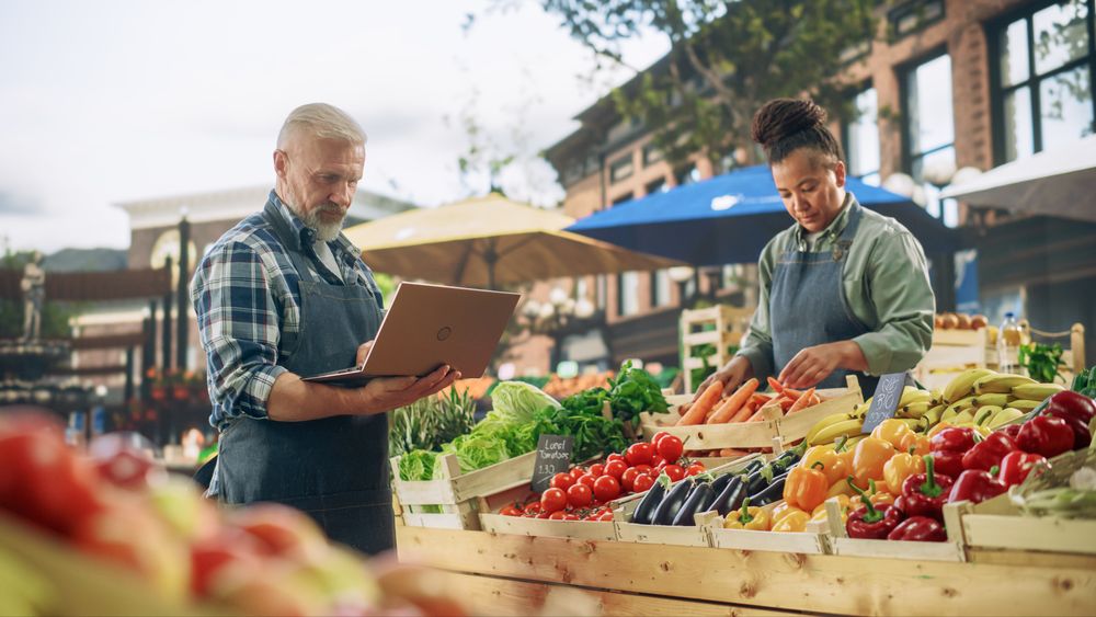 International Adult Partners Working at a Farmers Market.