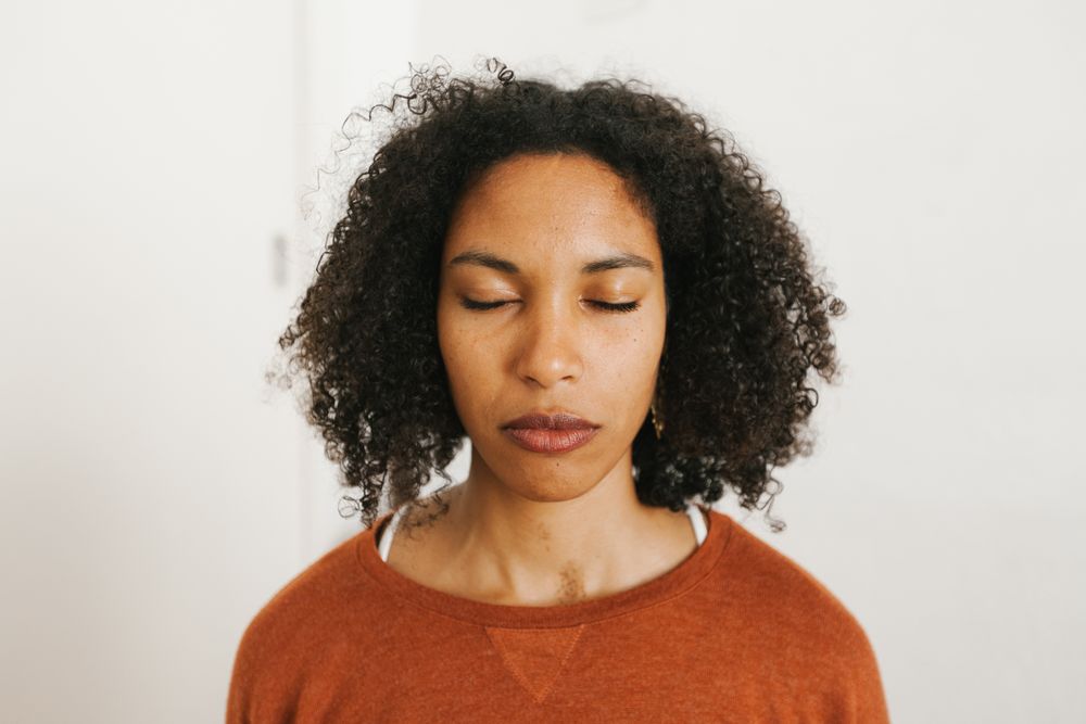 Portrait of young Black woman with closed eyes