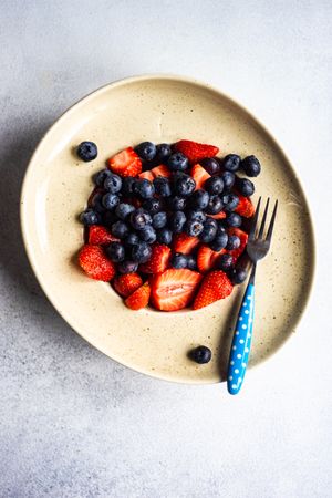 Ripe organic berries on modern ceramic plate