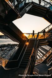 Silhouette of two people standing on stairs in modern building during golden hours 0KQ1D4