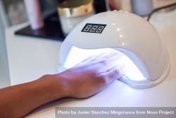 Manicured nails in UV lamp 49Kzy0