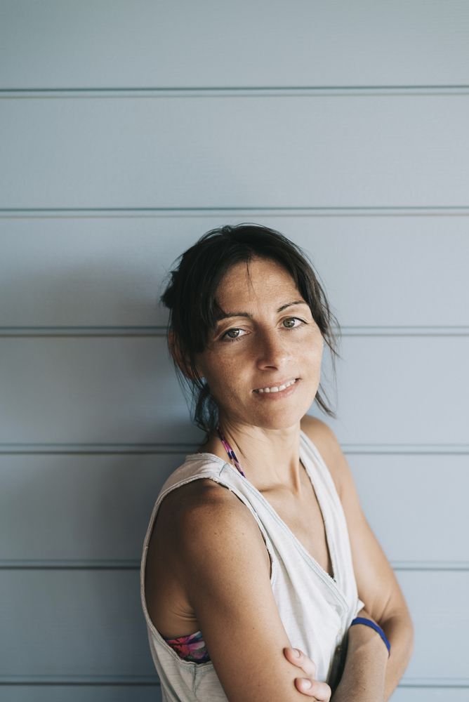 Portrait of hispanic woman with ponytail leaning on wood wall