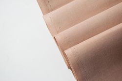 Multi folded light brown fabric background texture.