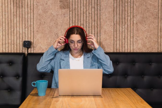 Female freelancer putting on headphones