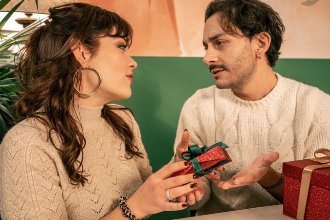 Romantic couple exchanging gifts during a Christmas celebration