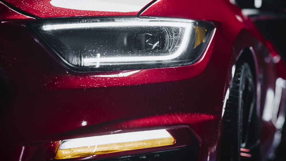 Beauty Close Up Footage of a Red Sportscar Drying Up After a Detailing Procedure ar a Professional Car Wash.