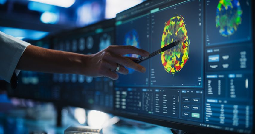 Modern Medical Research Center: Anonymous Doctor Pointing At Desktop Computer Monitor With CT Scan Of Human Spinal Cord.