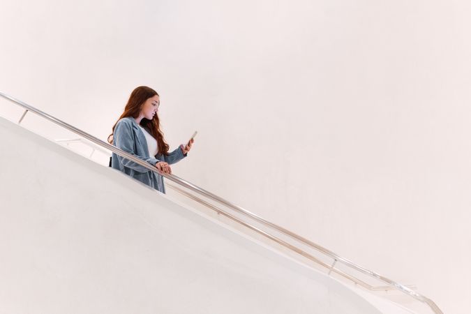 Woman browsing smartphone on staircase