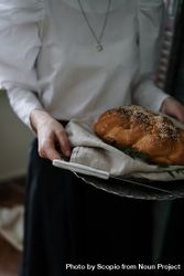 Cropped image of woman holding a silver tray with bread 42xqd0