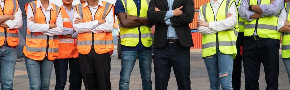 Wide shot of people in high vis jackets standing in a row