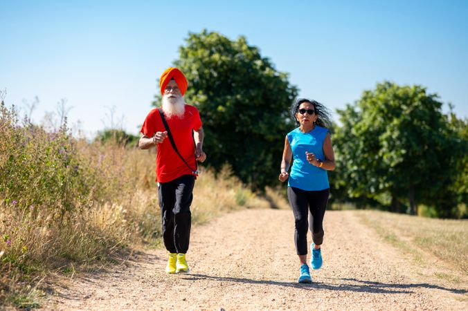 Mature Sikh couple jogging in park