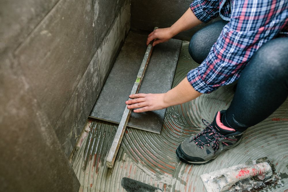 Female bricklayer checking floor with a level
