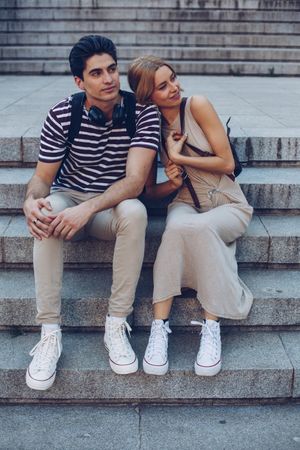 Young couple standing on ancient stairs against wall