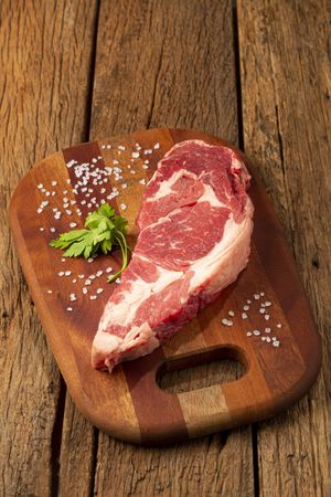 Raw ancho meat ready to roast on a wooden cutting board.