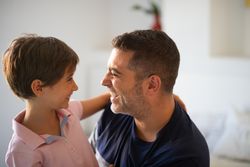Little girl and dad laughing with each other at home