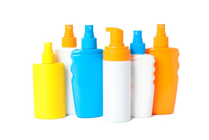 Many different sunscreen sprays isolated on blank background. Summer vacation accessories