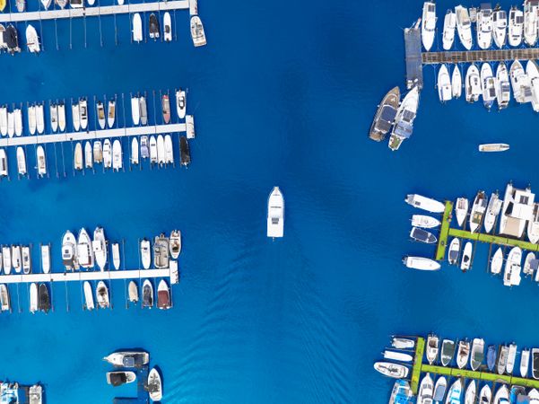 Aerial travel photo of a boat sailing into a beautiful port.
