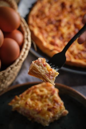 Crop person eating delicious quiche
