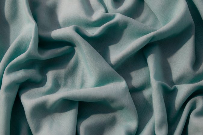 Nude green fabric wavy crumpled background texture with copy space.