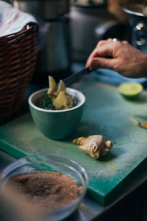 Person placing ginger slices in tea