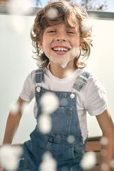 Cheerful boy playing with foam during cleaning