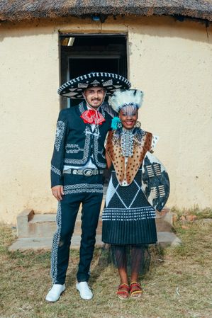 Zulu bride with her groom in traditional Mexican outfit m pose for wedding photo