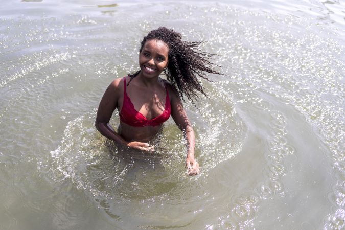 Black woman smiling and playing in a pool of water