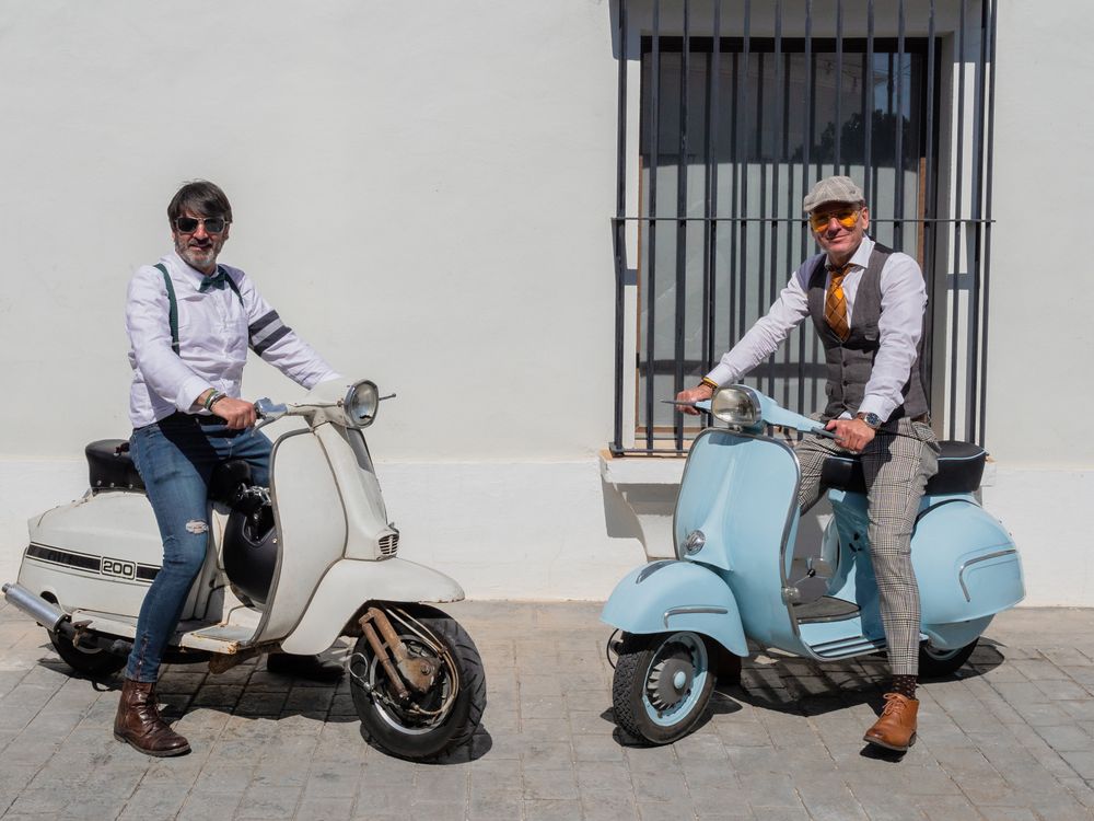 Trendy men sitting on vintage scooters