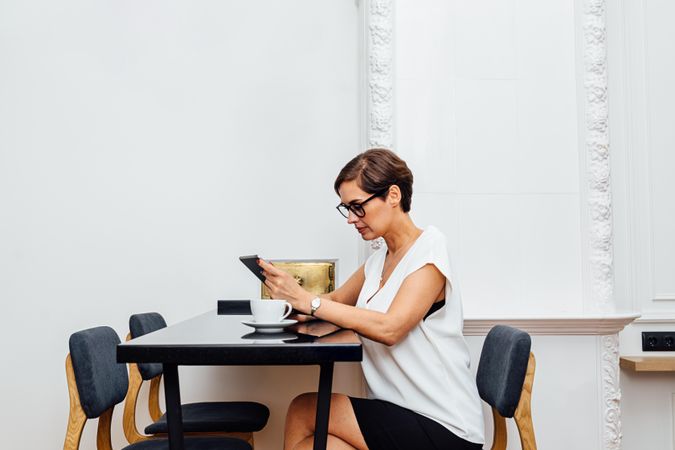 Woman checking her tablet with a coffee