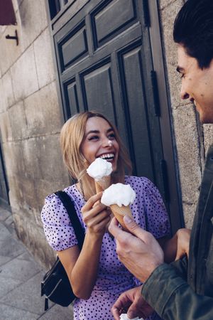 Happy couple feeding each other by ice cream