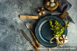 Table setting with branch and delicate nest on grey counter with copy space 4mWMpd