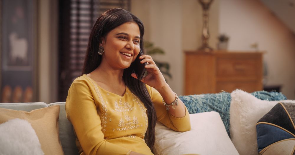 Portrait of Young Indian Woman Talking on Smartphone at Home: Discussing Work Projects, Planning a Social Event