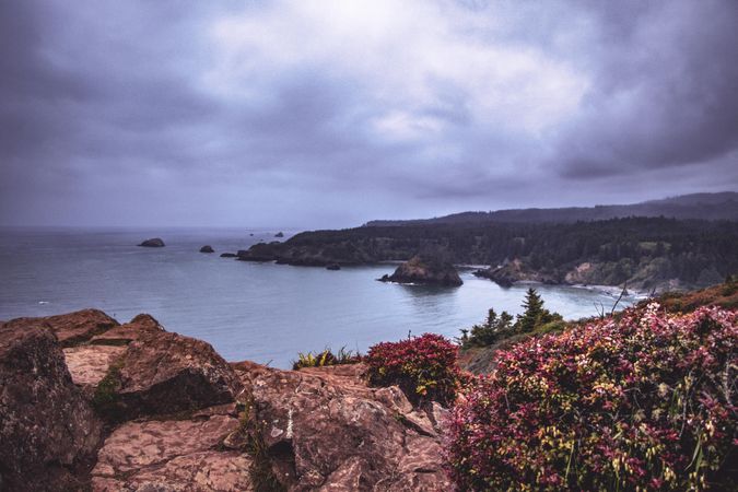 Looking down from rocky cliff at beautiful cove on a cloudy day