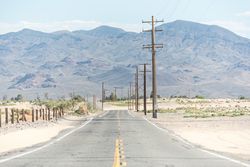 Asphalt road at scenic mountain valley and power line