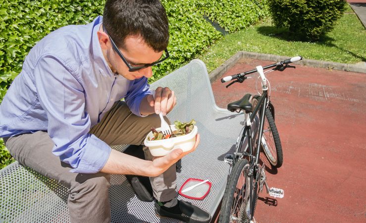 Young business man eating at lunch break outdoors
