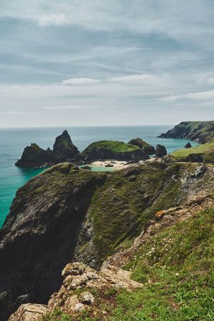 Beach nestled in the cliffs in Cornwall with cloudy sky