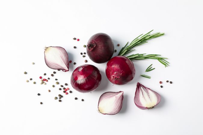 Flat lay composition with red onion and spices on plain background