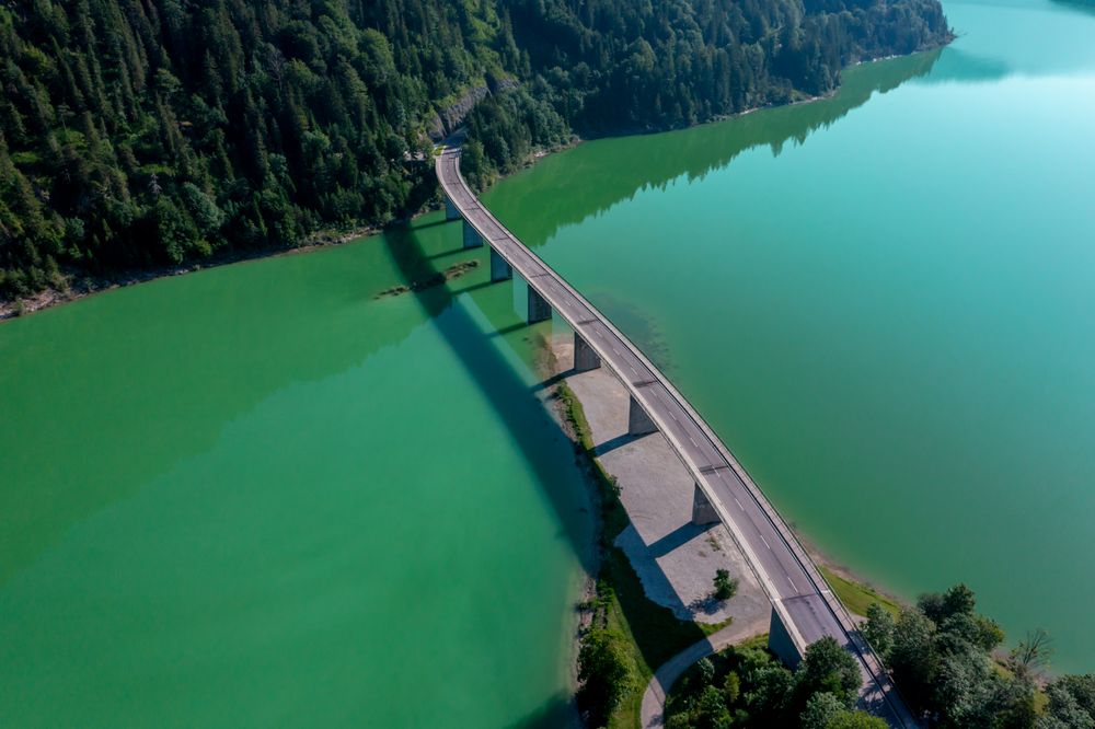 Drone shot with the bridge over Lake Sylvenstein in the bright light of summer
