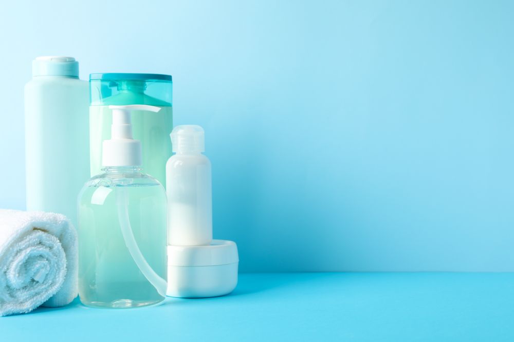 Body care products on blue background. Personal hygiene