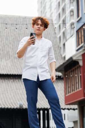 Asian man looking at mobile phone standing in the city