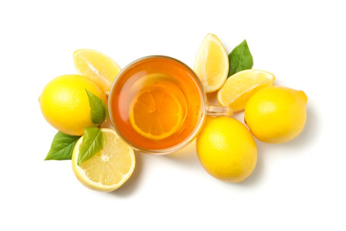 Tea and lemons isolated on bright background, top view