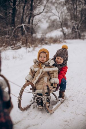 Two children in snow slide