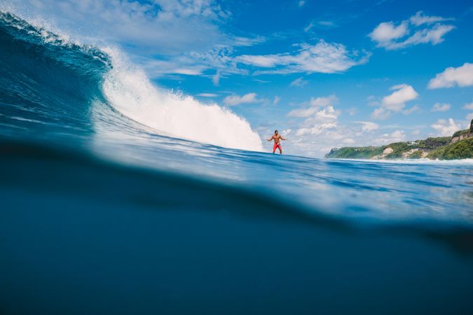 Man surfing sea waves under blue sky