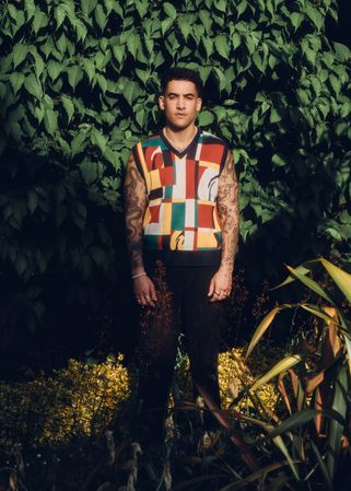 Portrait of male model standing in garden in graphic vest