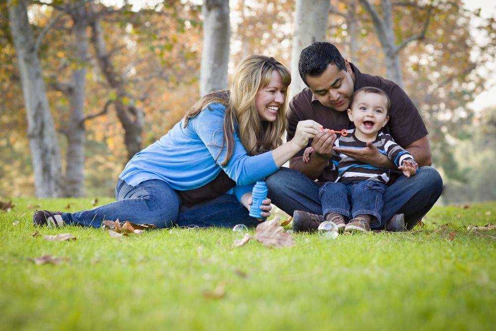 Happy Family Playing with Bubbles In The Park