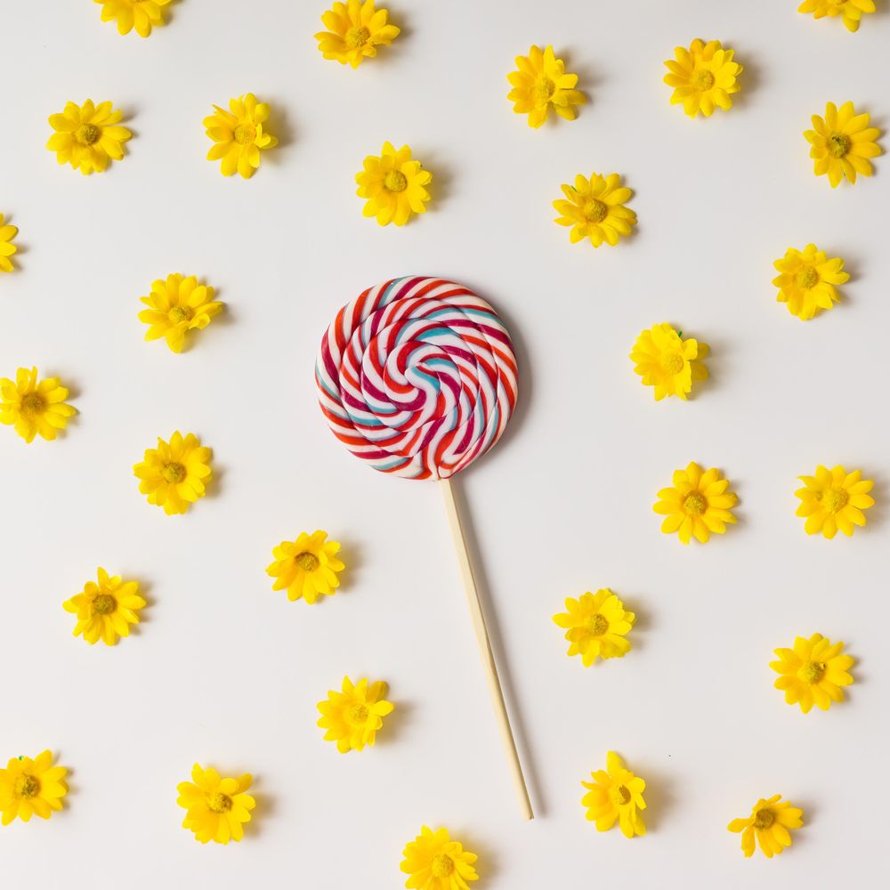 Swirling red lollipop and yellow flowers pattern